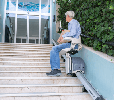 Senior using outdoor stair lift safely outside a home in Norfolk