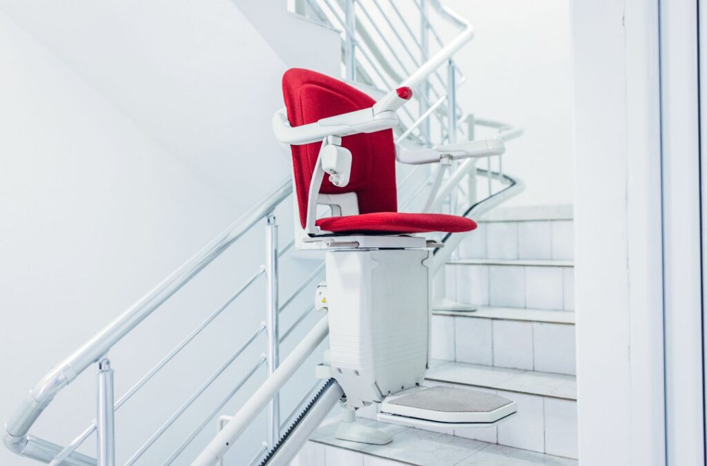 Technician installing a Custom Chair Stair Elevator rail along a residential staircase wall