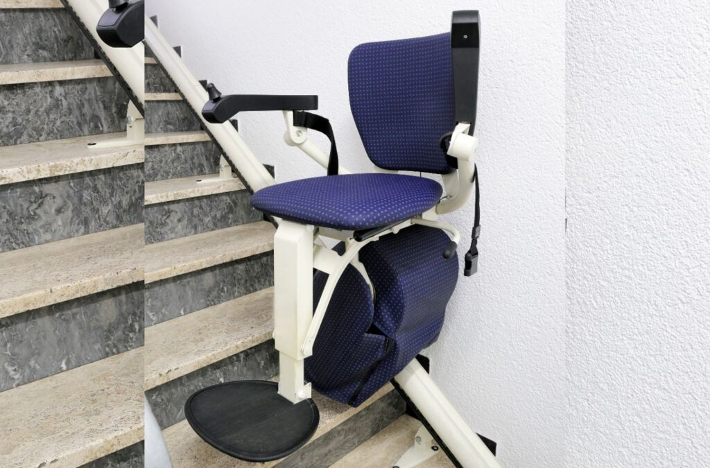 Mobility specialist checking Custom Chair Stair Elevator controls and rail positioning on a curved staircase. Custom Chair Stair Elevator near me.
