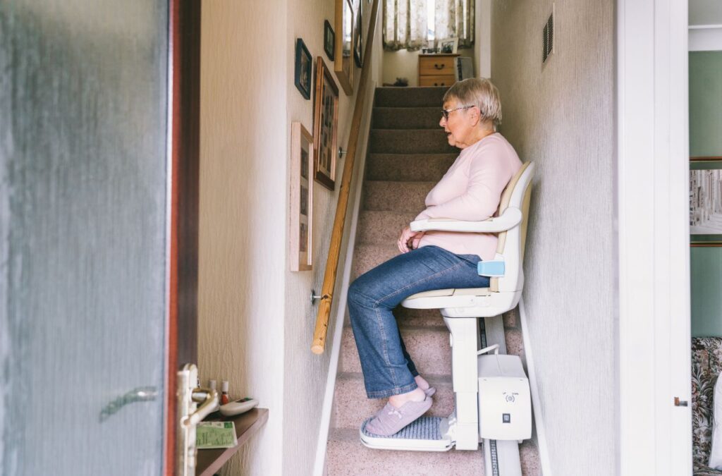 Technician adjusting a Custom Chair Stair Elevator seat height inside a multi-level family home